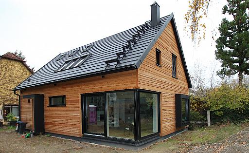 Holzhaus, Eingang und Wohnbereich von außen, Grundriss mit zentraler treppe, Schwarz eloxierte Metallelemente