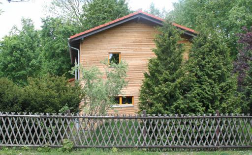 Haus, hervorstehendes Dach, Blick vom Zaun aus