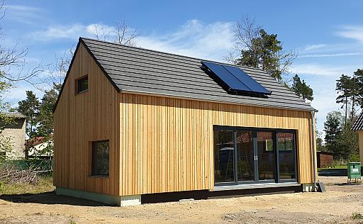 Holzhaus, große Glastüren, Solarpanele auf Dach